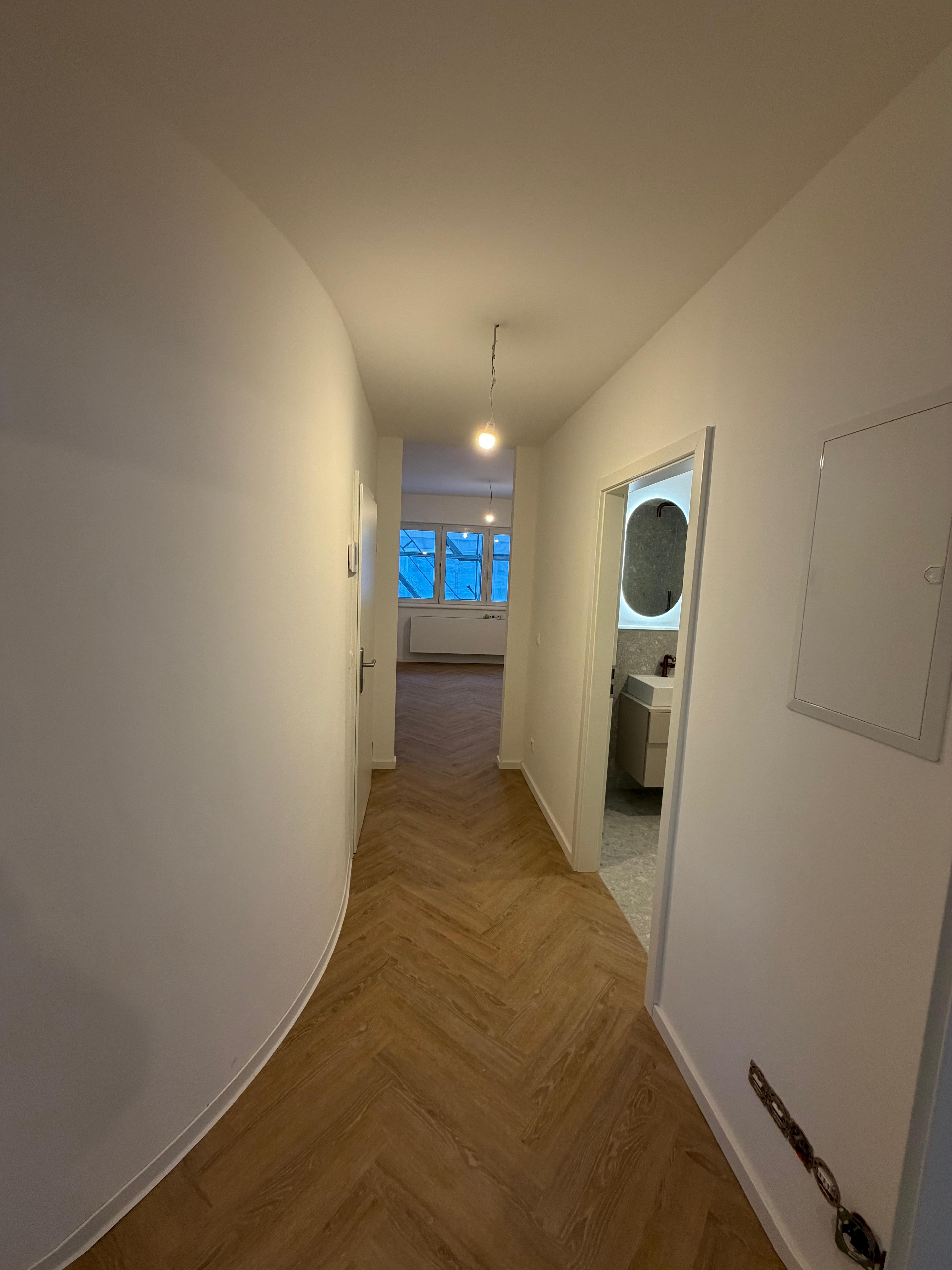 Energetische Sanierung Kriegerstraße, Stuttgart – Flur mit Fischgrätboden und Zugang zum Bad
